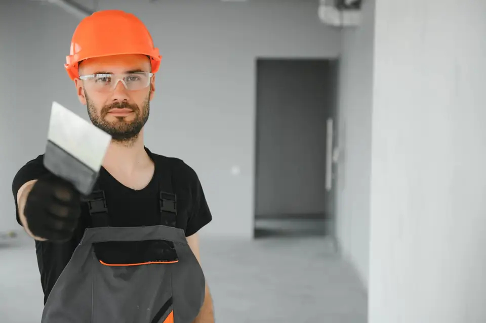 Fachhandwerker mit Schutzhelm und Spachtel